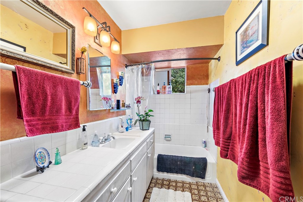 645 Griffith Way Laguna Beach, CA 92651 - Photo 14 of 55 a bathroom with a sink a mirror and a shower