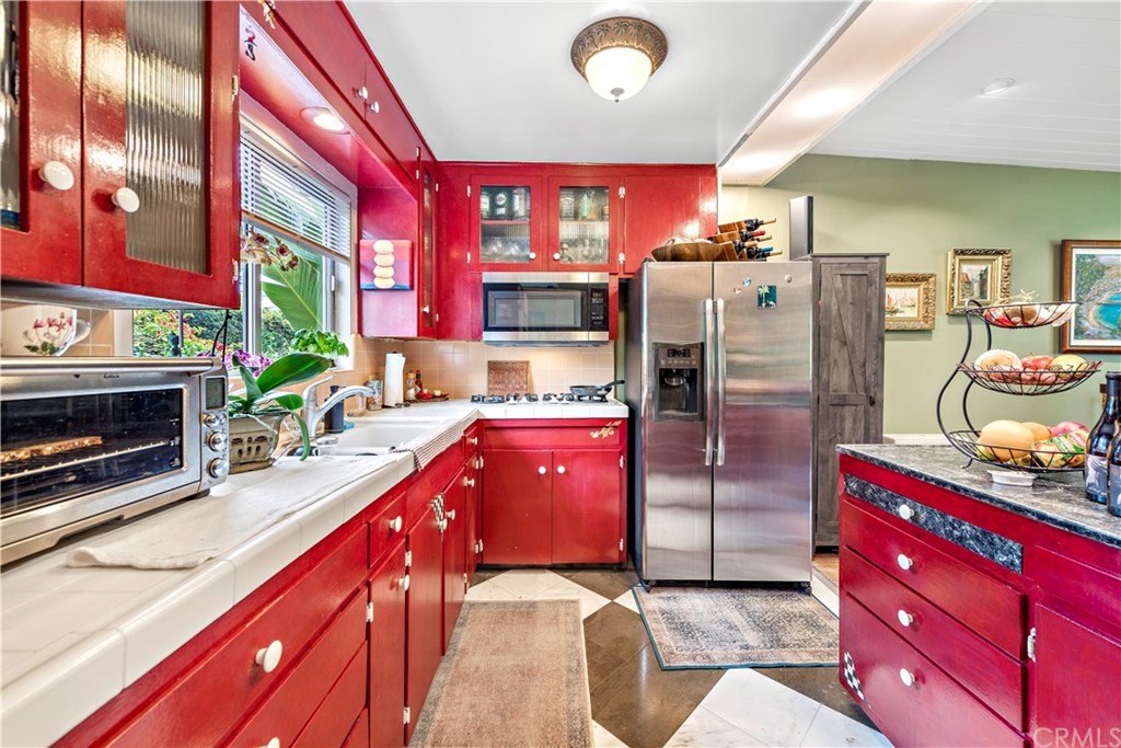 645 Griffith Way Laguna Beach, CA 92651 - Photo 5 of 55 a kitchen with stainless steel appliances kitchen island granite countertop a refrigerator and a stove