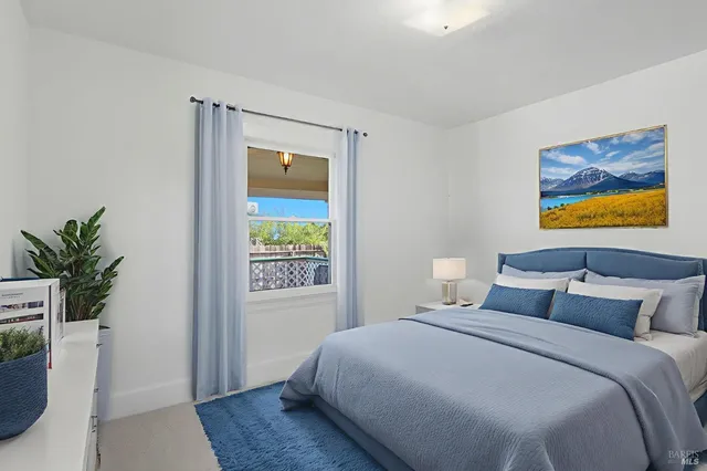 a bedroom with a bed and a potted plant