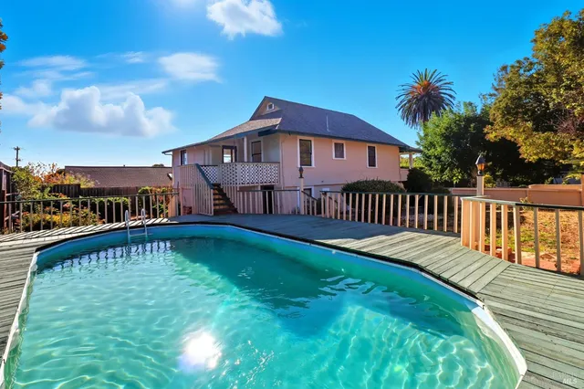 a view of a house with a yard deck and a patio
