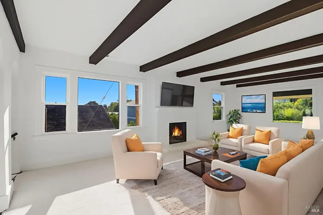 a living room with furniture a fireplace and a floor to ceiling window