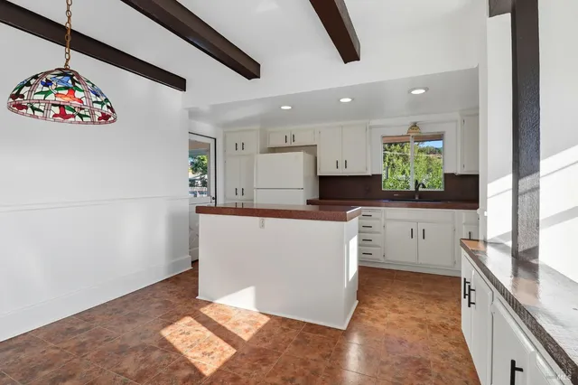 a kitchen with granite countertop white cabinets and white appliances