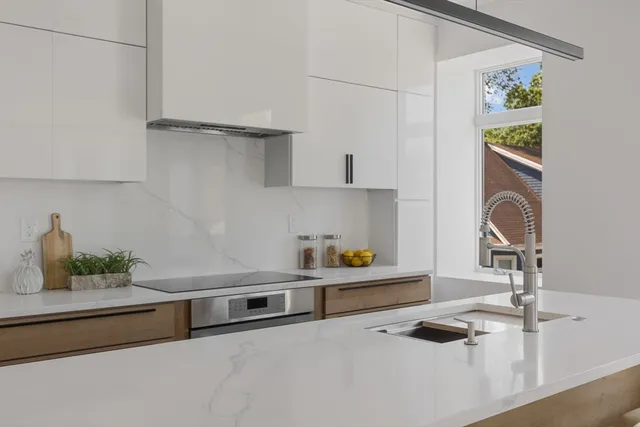 a kitchen with stainless steel appliances granite countertop a sink and a stove top oven