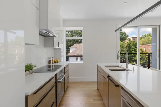 a kitchen with stainless steel appliances a sink a stove and a wooden floor