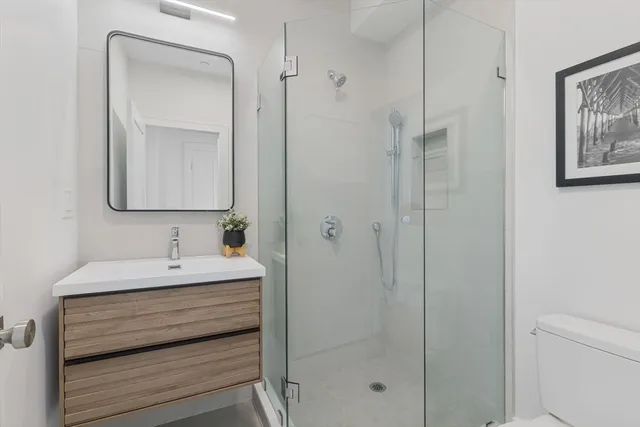 a bathroom with a shower a mirror and a sink