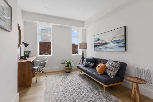 a living room with furniture and a potted plant
