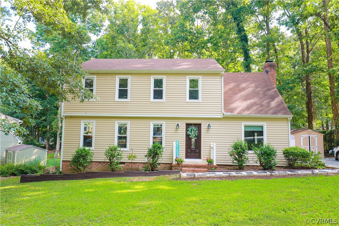 a front view of a house with a yard and green space