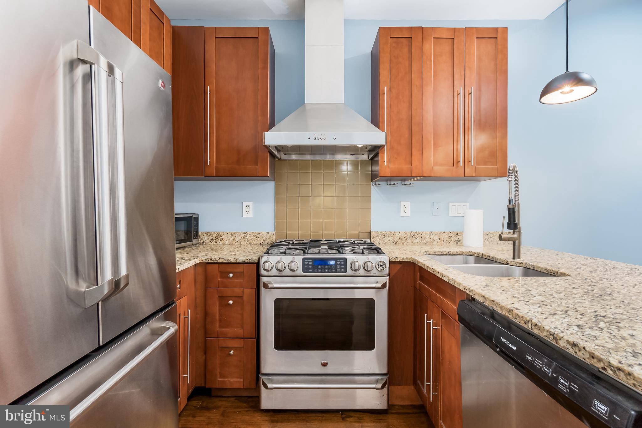 1553 9th Street Northwest, Unit A Washington, DC 20001 - Photo 7 of 30 a kitchen with stainless steel appliances granite countertop a stove a refrigerator and a stove