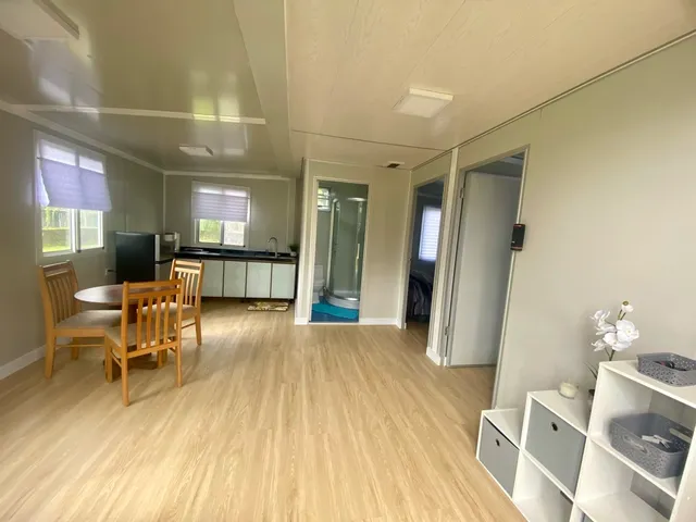 a view of a hallway with wooden floor and furniture