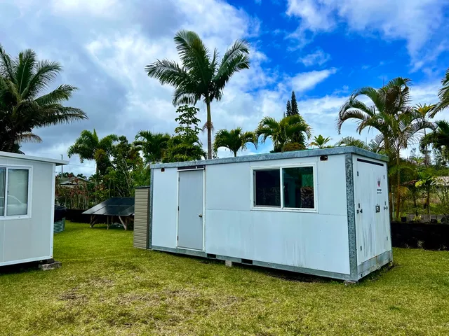 a view of a house with a yard and potted plants