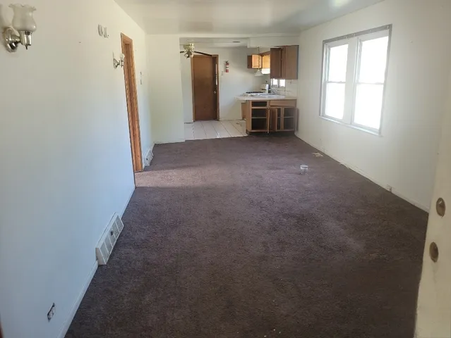 a view of a kitchen with refrigerator and window