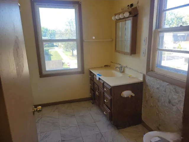 a bathroom with a tub sink vanity and a mirror