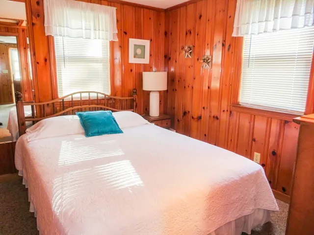 a bed sitting in a bedroom next to a window