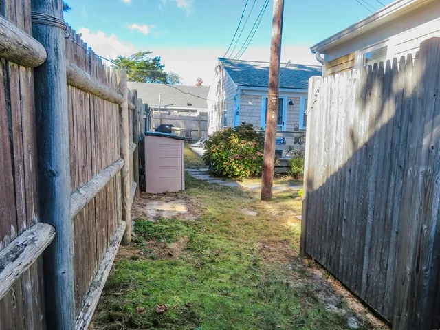 a view of a backyard with wooden fence