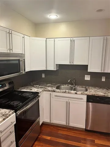 a kitchen with a sink stove top oven and cabinets