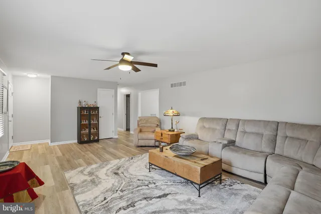 a living room with furniture ceiling fan and a rug