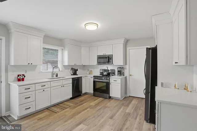 a kitchen with a refrigerator sink and wooden cabinets