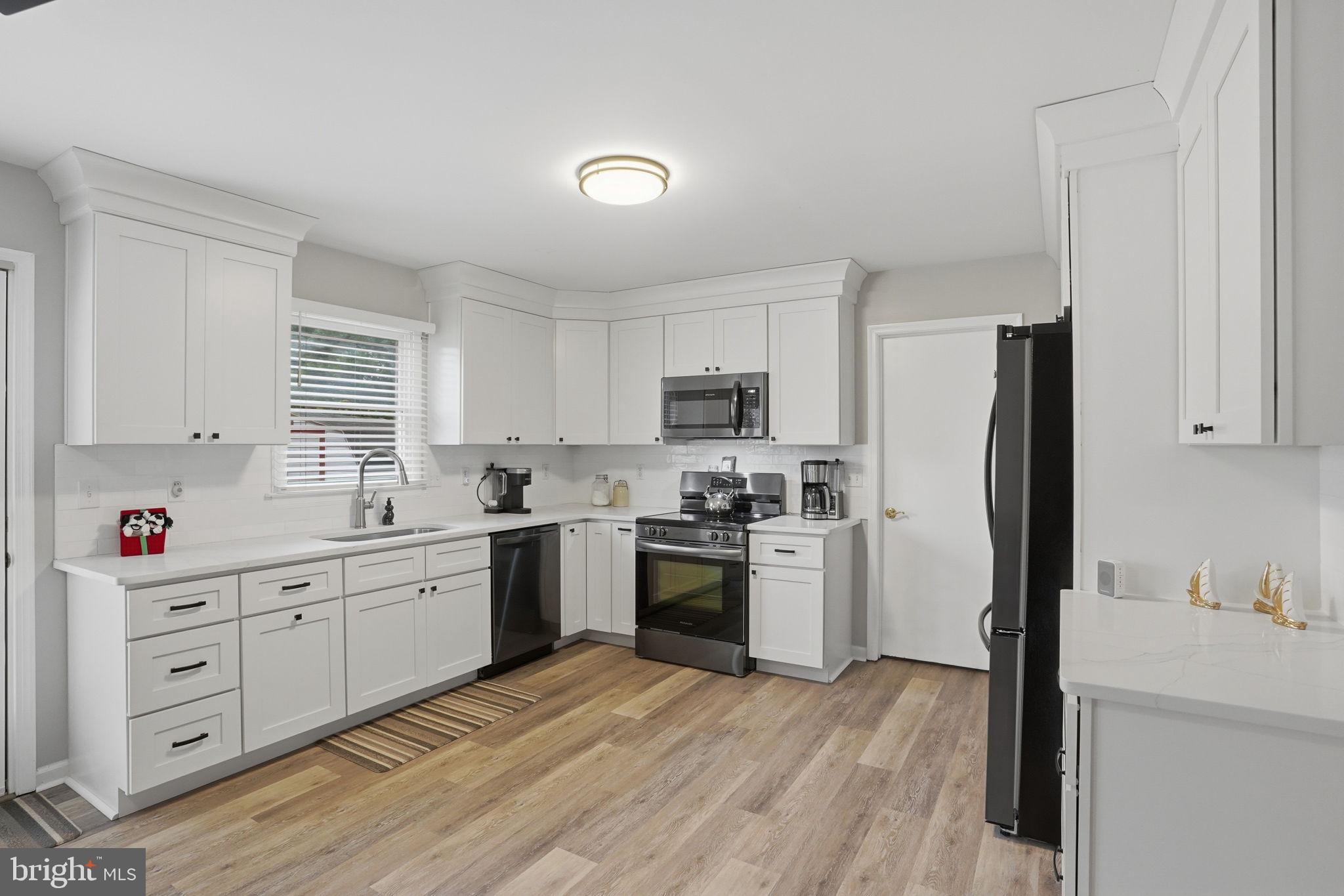 251 Misty Ridge Drive Magnolia, DE 19962 - Photo 8 of 33 a kitchen with a refrigerator sink and wooden cabinets