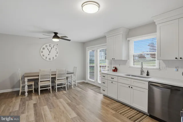 a kitchen with a dining table chairs and white cabinets
