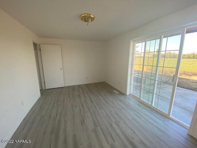 2807 Nelson Road Yakima, WA 98903 - Photo 6 of 11 an empty room with wooden floor and windows