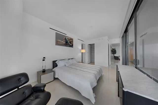 a bedroom with a large window and a bed