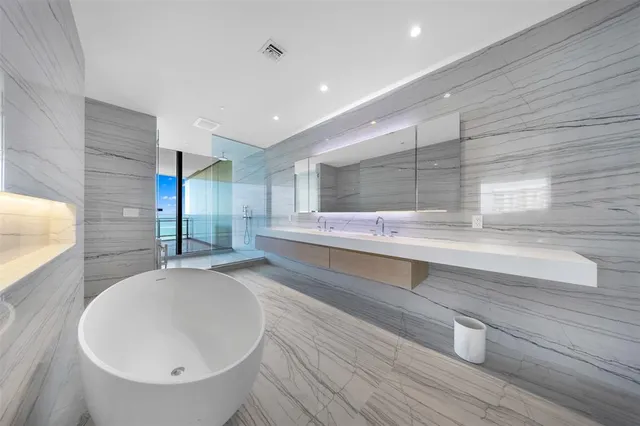 a spacious bathroom with double vanity and a bathtub