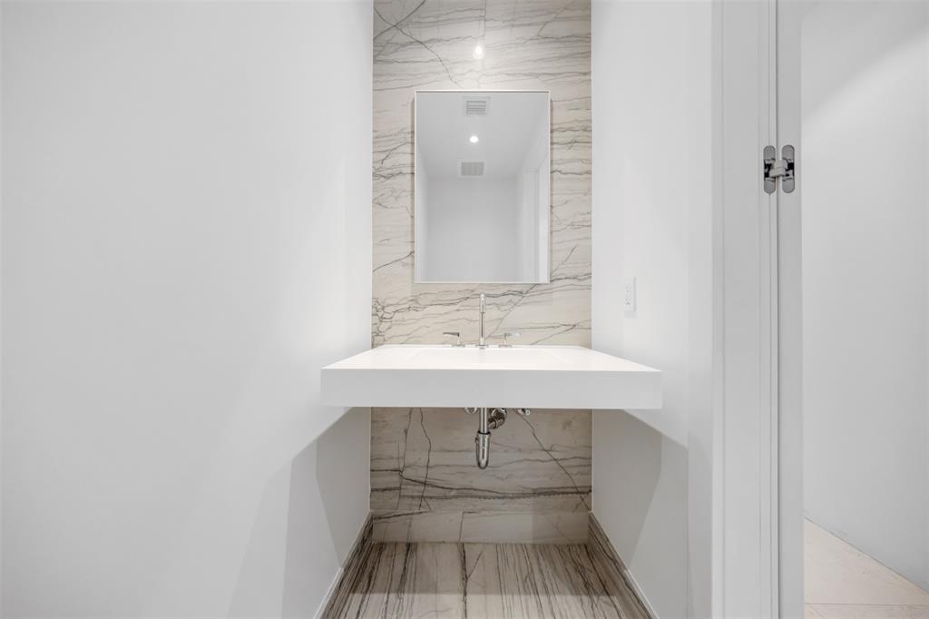 8701 Collins Avenue, Unit 701 Surfside, FL 33154 - Photo 35 of 91 a bathroom with a sink a mirror and wooden floor