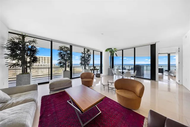 a living room with furniture potted plant and a large window