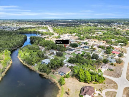 an aerial view of ocean and residential houses with outdoor space
