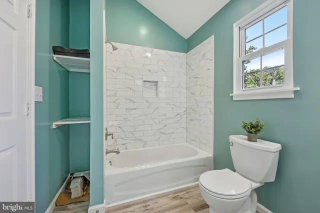a view of a big room with windows and chandelier fan