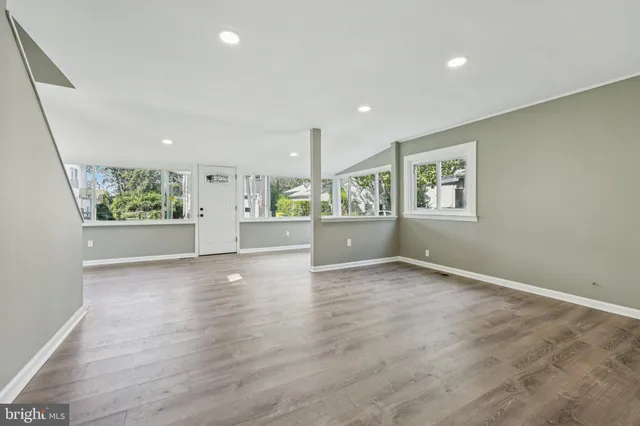 a view of a hallway with wooden floor and a window
