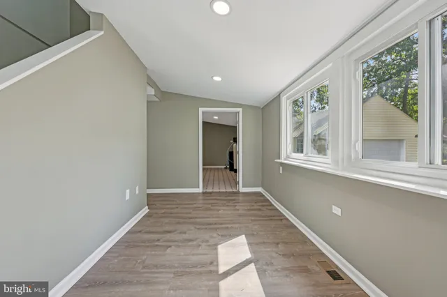 a view of an entryway with wooden floor and a livingroom