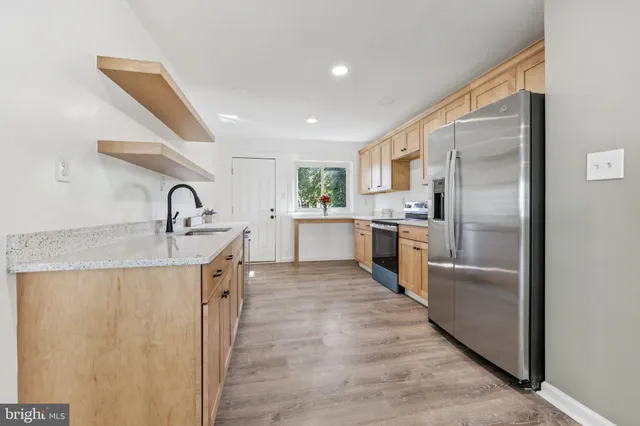 a kitchen with stainless steel appliances granite countertop a refrigerator and a sink