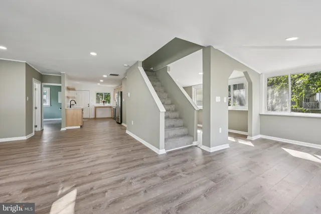 a view of a livingroom with wooden floor and stairs