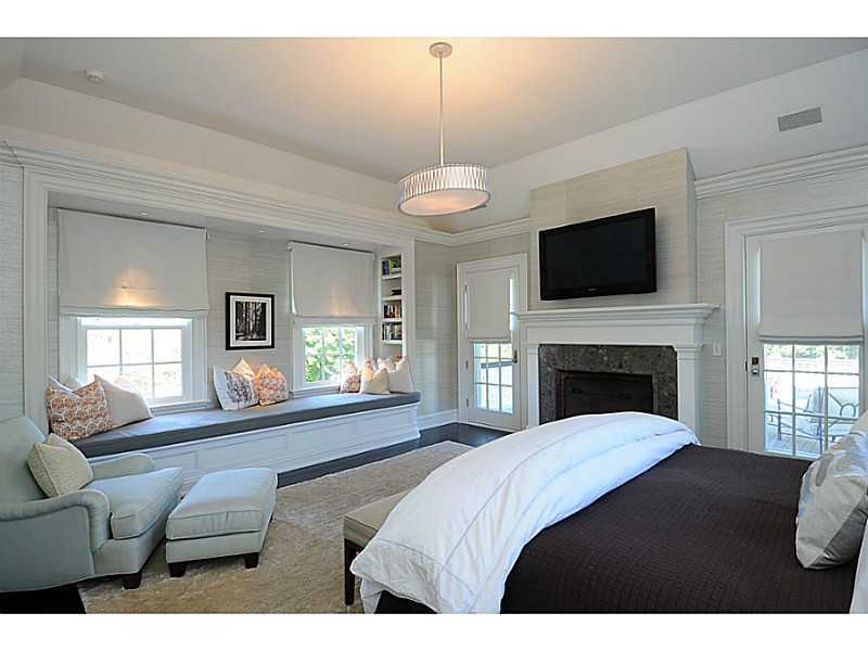 581 Sasco Hill Road Fairfield, CT 06824 - Photo 13 of 25 a view of a livingroom with a fireplace a flat screen tv and windows