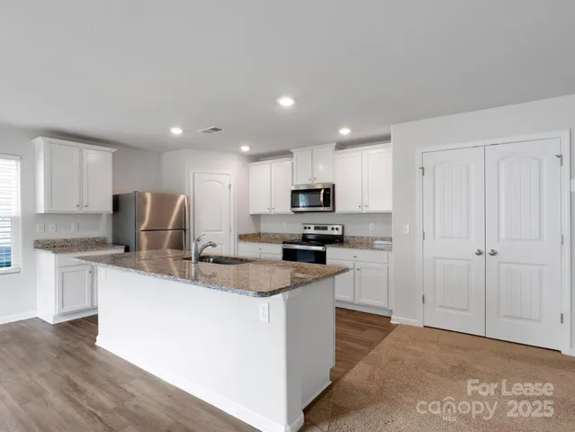 a kitchen with stainless steel appliances granite countertop a stove top oven a sink and a granite counter tops