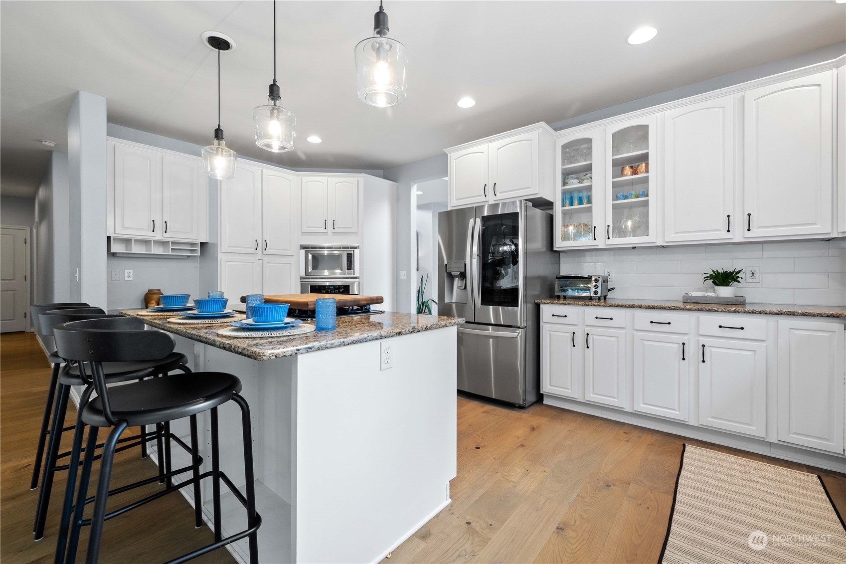 27648 Maple Ridge Way Southeast Maple Valley, WA 98038 - Photo 8 of 40 a kitchen with stainless steel appliances granite countertop a stove a sink dishwasher a refrigerator and white cabinets with wooden floor