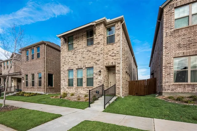a front view of a house with a garden and garage