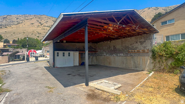 120 North 1230 E Street Springville, UT 84663 - Photo 41 of 60 Covered carport structure with an exposed wood-frame ceiling and a concrete floor