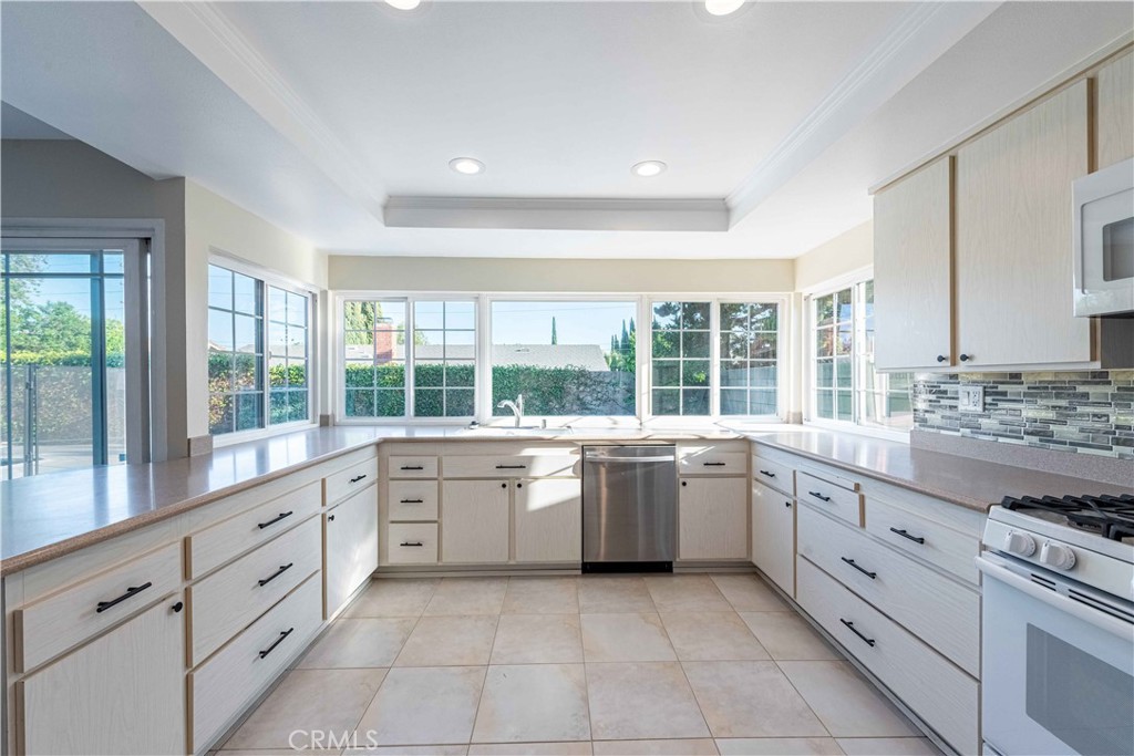 2232 Hawk Street Simi Valley, CA 93065 - Photo 13 of 39 a large white kitchen with granite countertop a stove top oven sink and cabinets