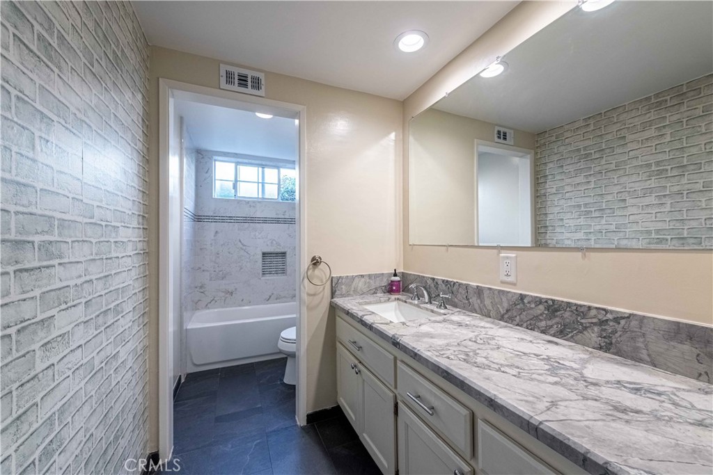 2232 Hawk Street Simi Valley, CA 93065 - Photo 28 of 39 a bathroom with a granite countertop double vanity sink a mirror and a bathtub