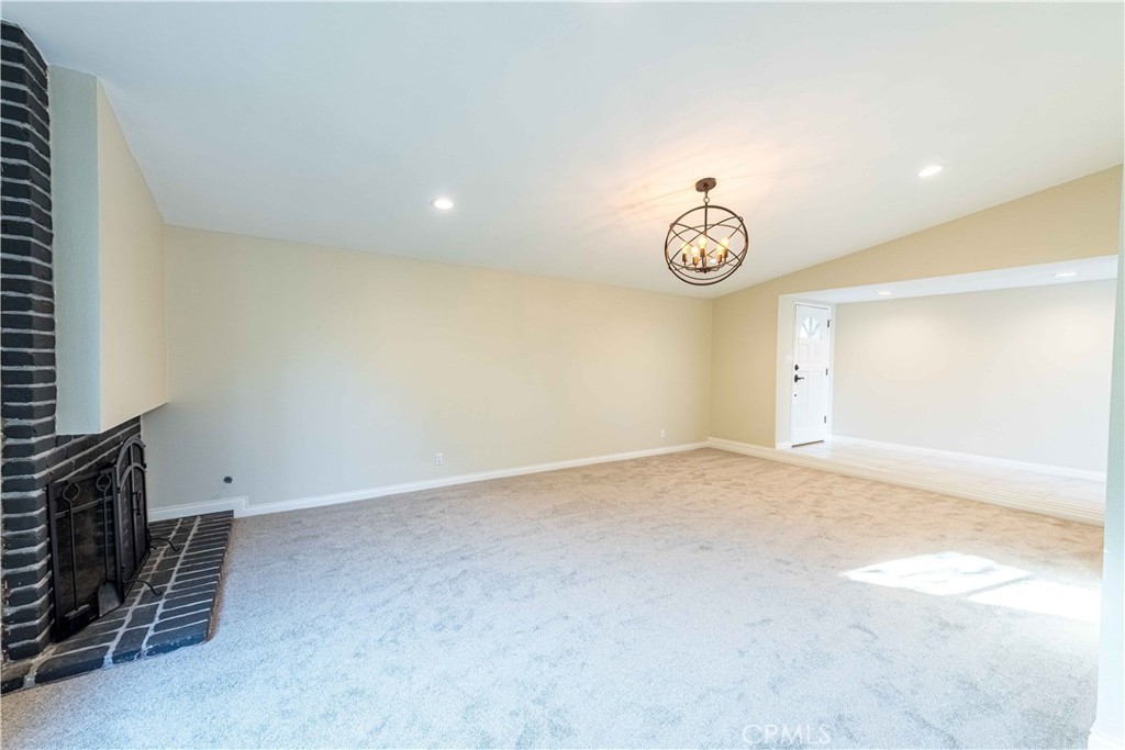 2232 Hawk Street Simi Valley, CA 93065 - Photo 6 of 39 an empty room with a fireplace and a chandelier fan