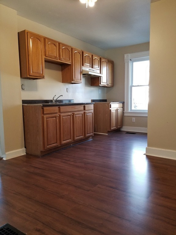 19 Merrick Avenue Springfield, MA 01109 - Photo 7 of 20 a kitchen with stainless steel appliances granite countertop a sink a microwave cabinets and wooden floor