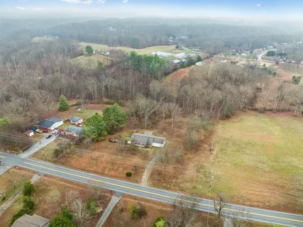 a brick house next to a yard with a large tree