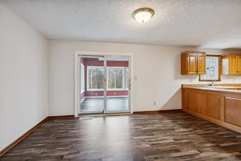 a view of a kitchen with a sink and dishwasher with wooden floor
