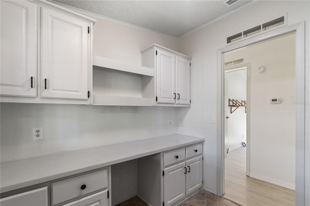 701 Helmsman Lane Edgewater, FL 32141 - Photo 16 of 73 a kitchen with white cabinets and a sink