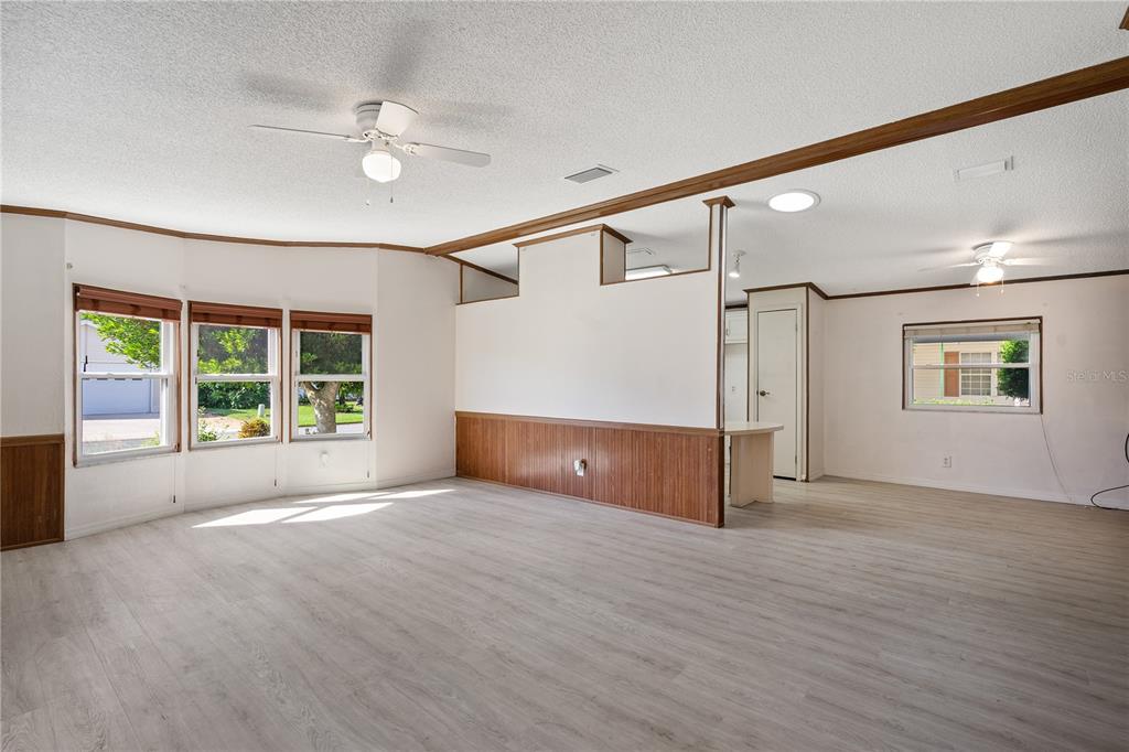 701 Helmsman Lane Edgewater, FL 32141 - Photo 10 of 73 a view of an empty room with a window and wooden floor