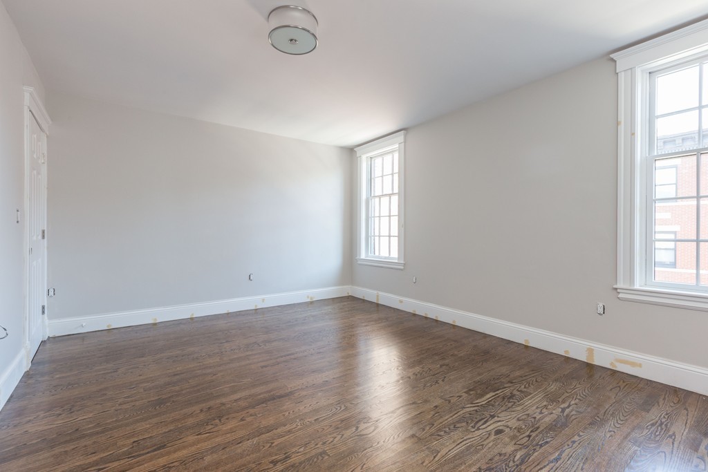 290 North Street, Unit 2 Boston, MA 02113 - Photo 4 of 8 an empty room with wooden floor and windows
