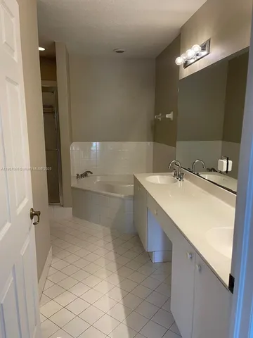 a bathroom with a sink vanity granite tub and shower