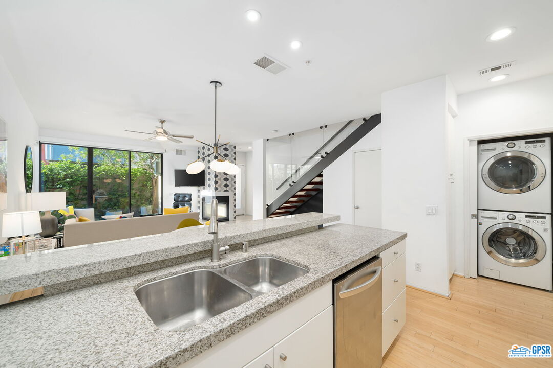 665 East Arenas Road Palm Springs, CA 92262 - Photo 13 of 40 a view of a kitchen counter top space with a sink wooden floor and a chandelier
